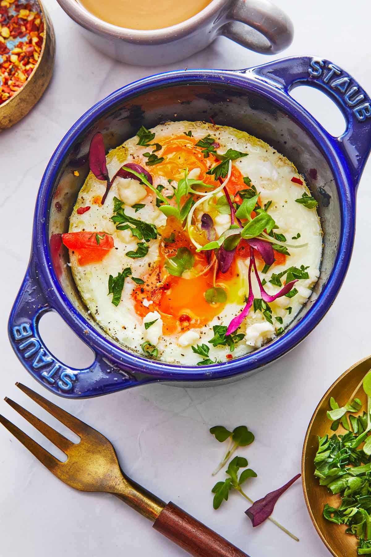 cooked baked eggs in a small baking dish next to a fork.