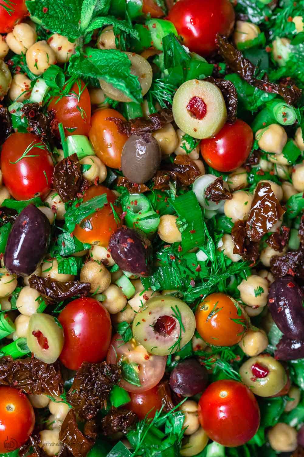 Balela Salad Recipe | The Mediterranean Dish. Bright, flavor-packed Mediterranean chickpea salad with chopped veggies, lots of herbs, and favorites like olives and sun-dried tomatoes. A zesty dressing brings it all together! A simple recipe from TheMediterraneanDish.com #balela #chickpeasalad #mediterraneanfood #mediterraneanrecipe