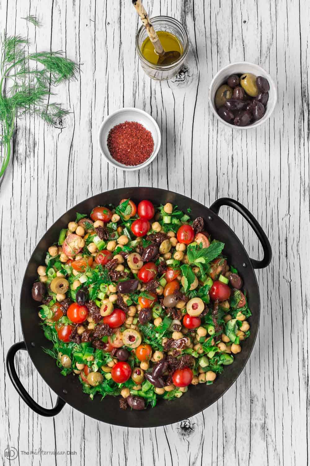 Balela Salad Recipe | The Mediterranean Dish. Bright, flavor-packed Mediterranean chickpea salad with chopped veggies, lots of herbs, and favorites like olives and sun-dried tomatoes. A zesty dressing brings it all together! A simple recipe from TheMediterraneanDish.com #balela #chickpeasalad #mediterraneanfood #mediterraneanrecipe