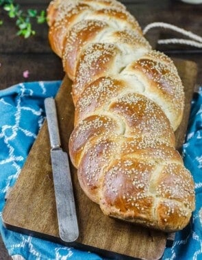 Challah bread on a cutting board with a knife