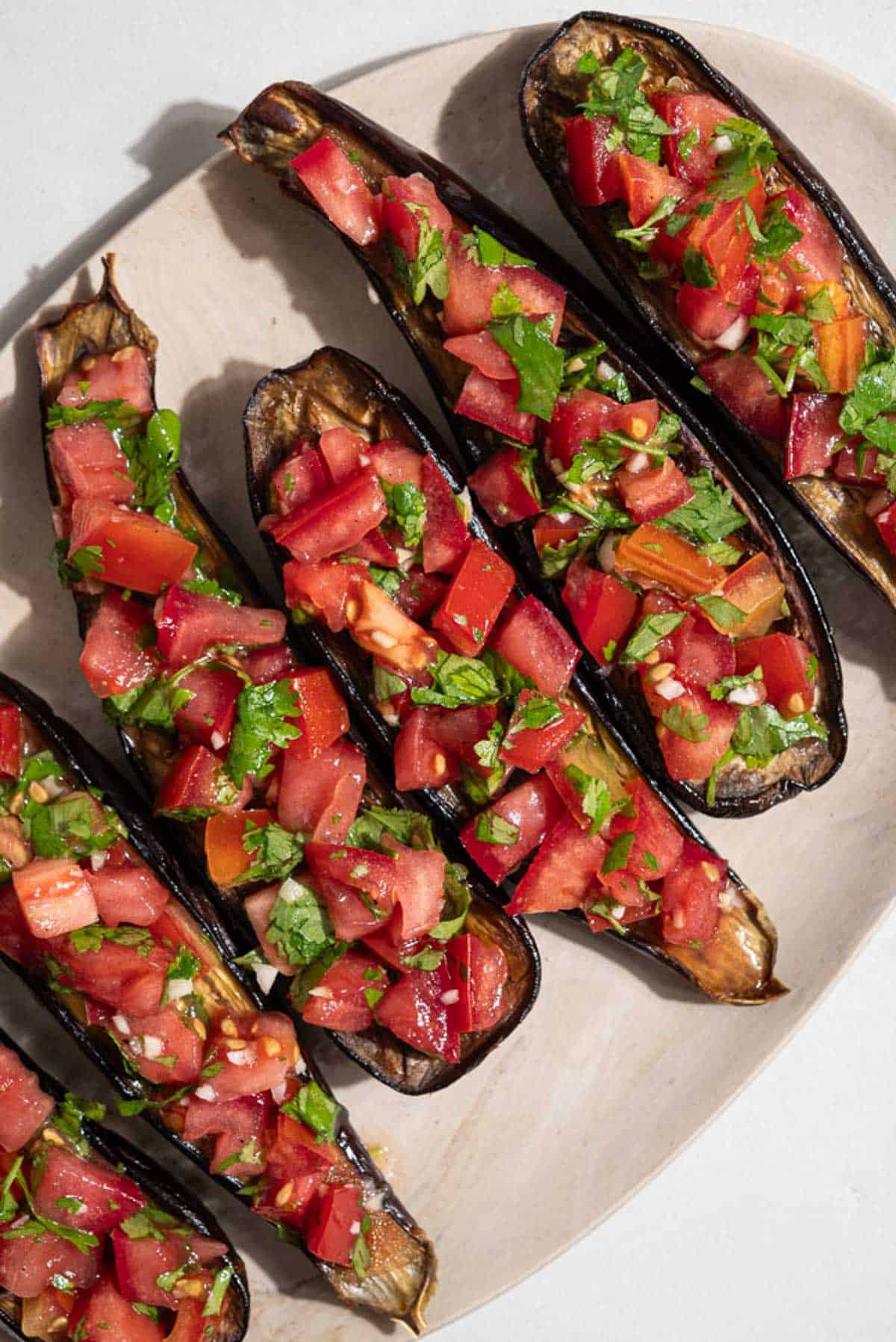 An overhead photo of 4 pieces of eggplant bruschetta on a platter.