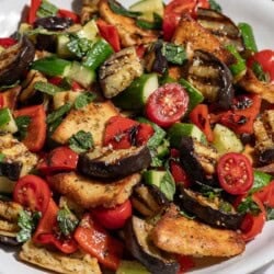 A close up of grilled eggplant salad on a serving platter.