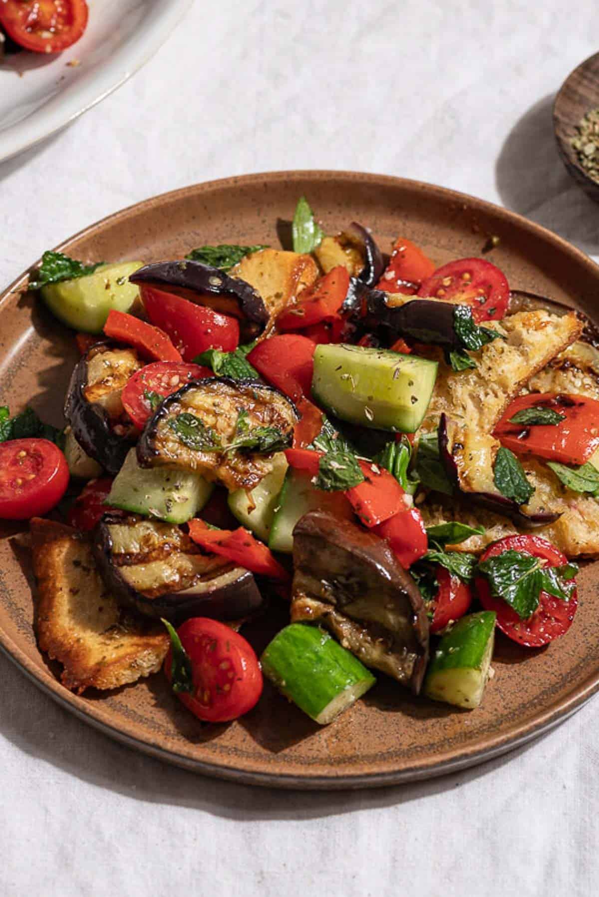 A close up of grilled eggplant salad on a plate.