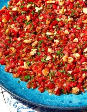 A close up photo of ezme turkish salsa on a platter.