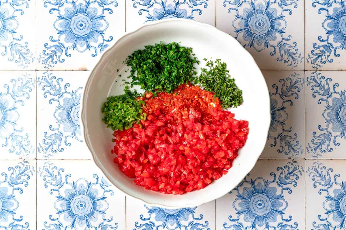 The ingredients for the ezme turkish salsa in a bowl just before being mixed together.