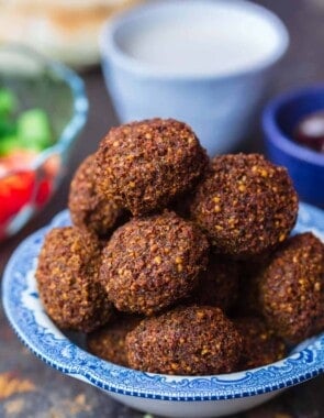 Falafel served in bowl with a side salad, tahini and pita bread