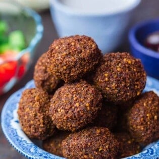 Falafel served in bowl with a side salad, tahini and pita bread