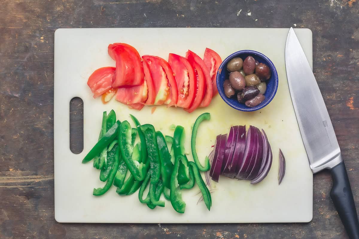 Toppings for chicken gyro, including tomatoes, green peppers, onions, and olives.