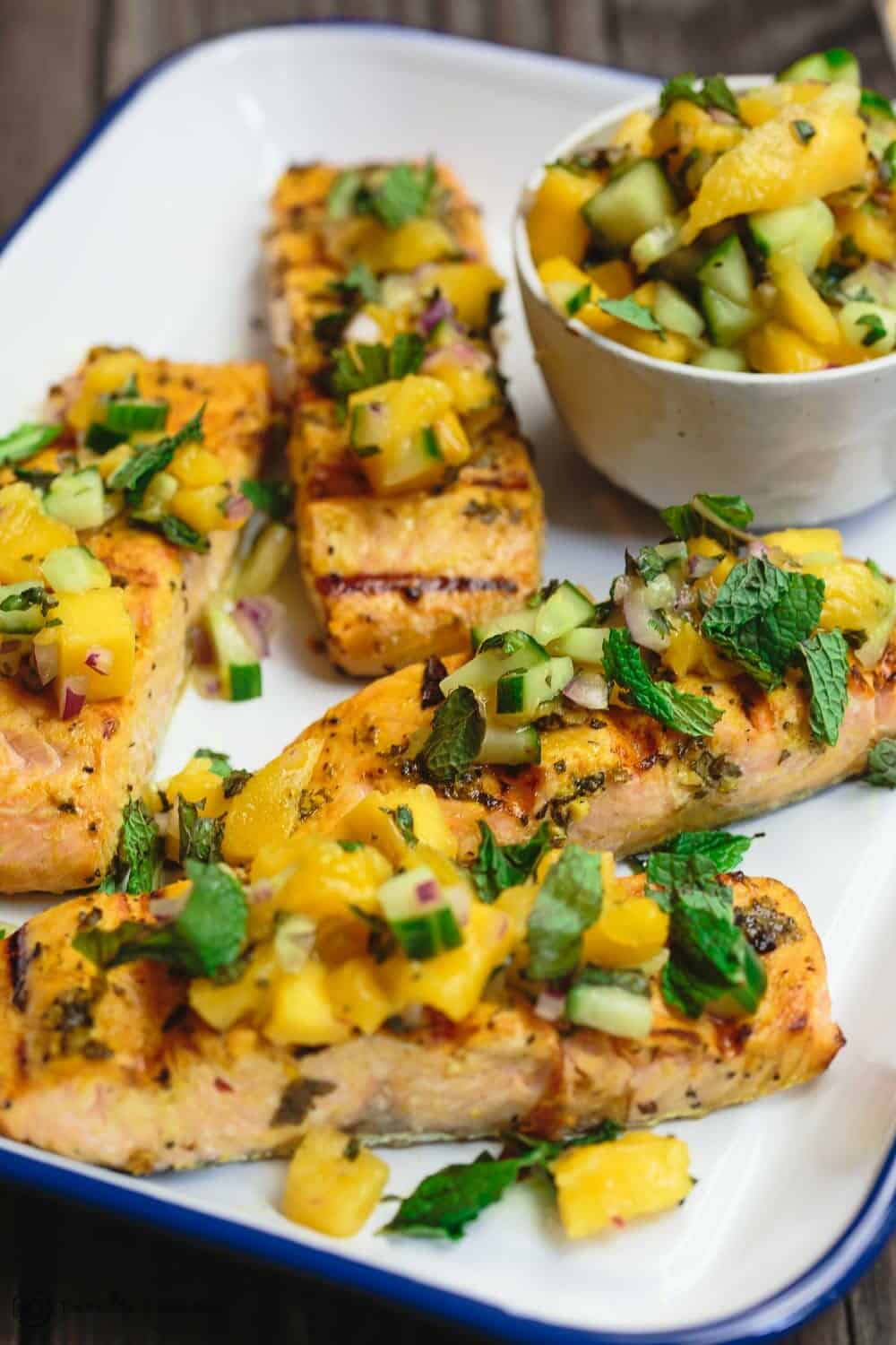 Easy Grilled Salmon Recipe | The Mediterranean Dish. Learn how to grill salmon perfectly every single time. Plus, the perfect salmon marinade with fresh herbs and Mediterranean spices. The fresh mango salsa on top is optional but so worth trying. Recipe from TheMediteraneanDish.com #salmon #grilledsalmon #mediterraneanfood #mediterraneandiet #glutenfreerecipes