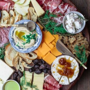 To make the best cheese board, you need a variety of four cheeses, meats, and accompaniments