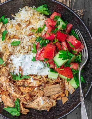 Lebanese Chicken Fatteh Dinner Bowls | The Mediterranean Dish. Flavor-packed Lebanese chicken recipe with toasted pita, rice and a simple Mediterranean salad all in one bowl. Check out the full recipe on TheMediterraneanDish.com