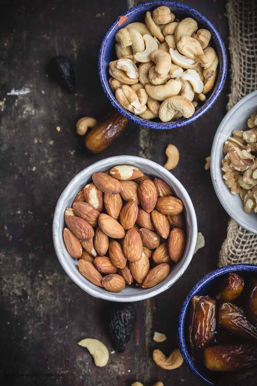 Assorted nuts and dried fruit including unsalted almonds, cashews, walnuts, dates. Mediterranean diet snacks