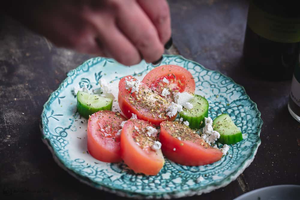 Sliced tomatoes and cucumbers with Za'atar spice and a sprinkle of feta 