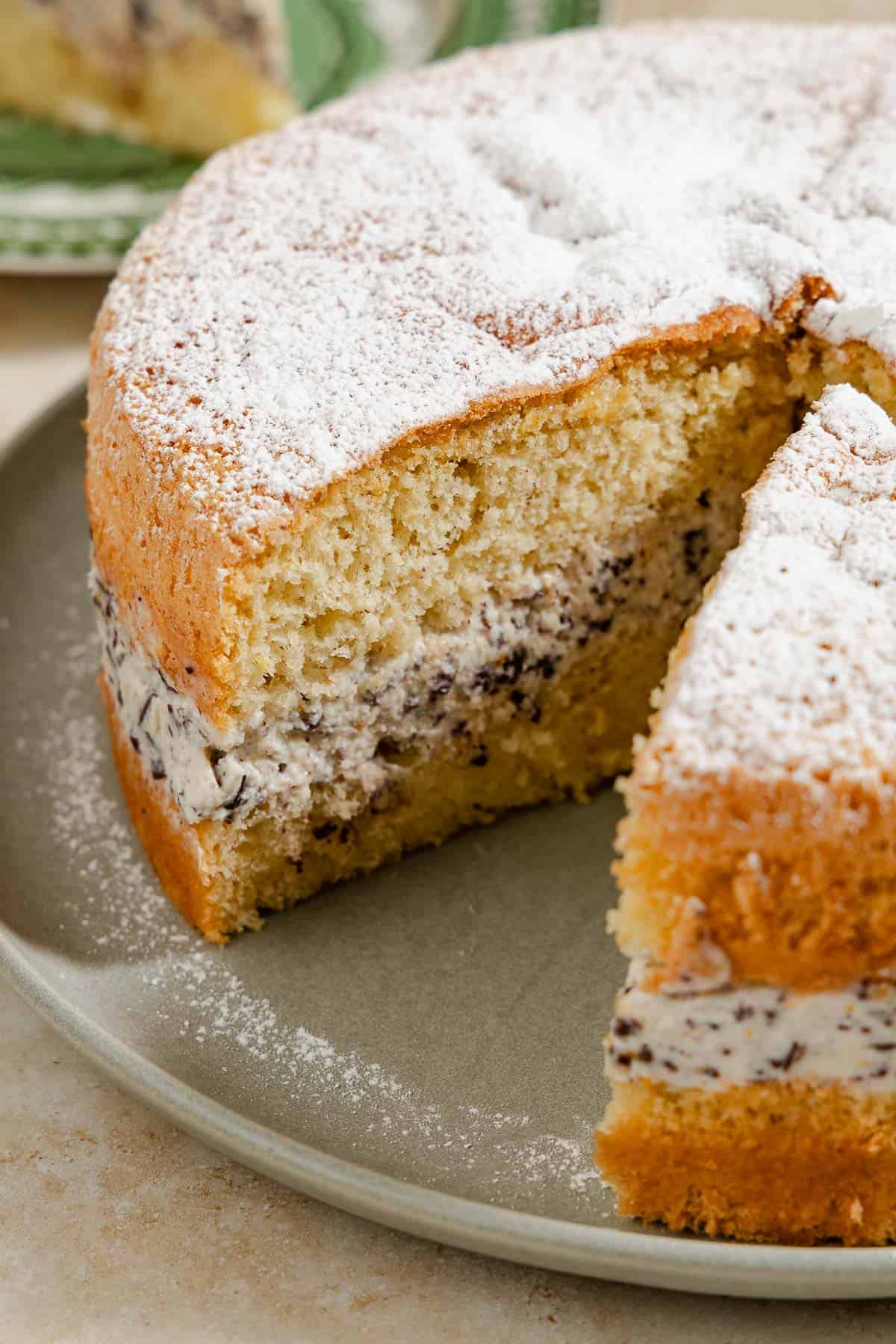 The easy cassata cake on a platter with a slice of it removed.