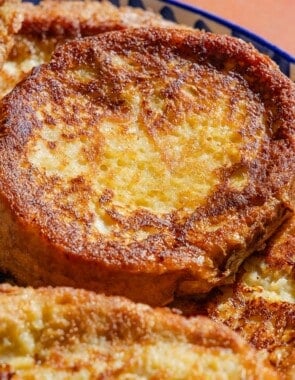 A close up photo of several torrijas on a serving platter.