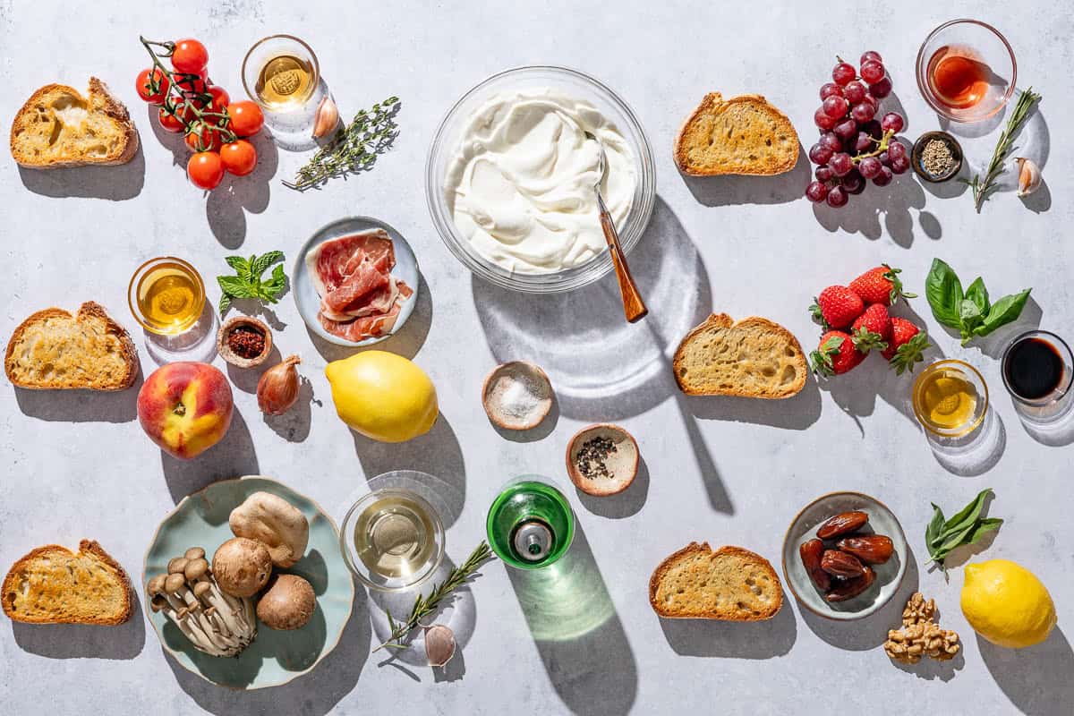 Ingredients for ricotta toast including ricotta, olive oil, salt, black pepper, slices of toasted bread, cherry tomatoes, garlic, thyme, sherry vinegar, shallot, lemons, peach, grapes, strawberries, dates, mint, basil, aleppo pepper, honey, mushrooms, rosemary, white wine, red wine vinegar, fennel sedds, balsamic vinegar, walnuts, and sage.