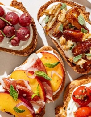 An overhead close up photo of an assortment of the ricotta toasts on a serving plate.