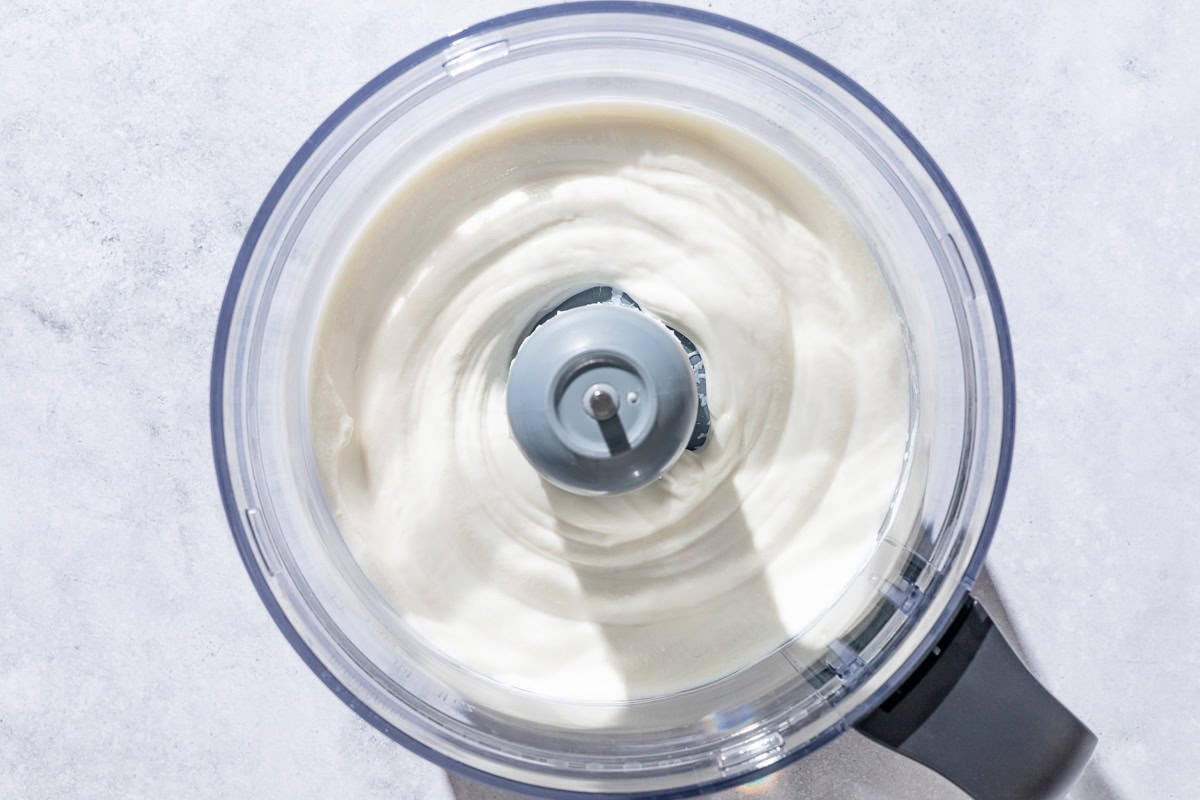 Whipped ricotta in the bowl of a food processor.