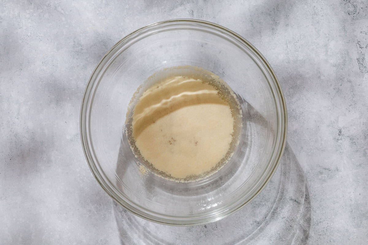 Yeast being activated in a bowl with water and honey.