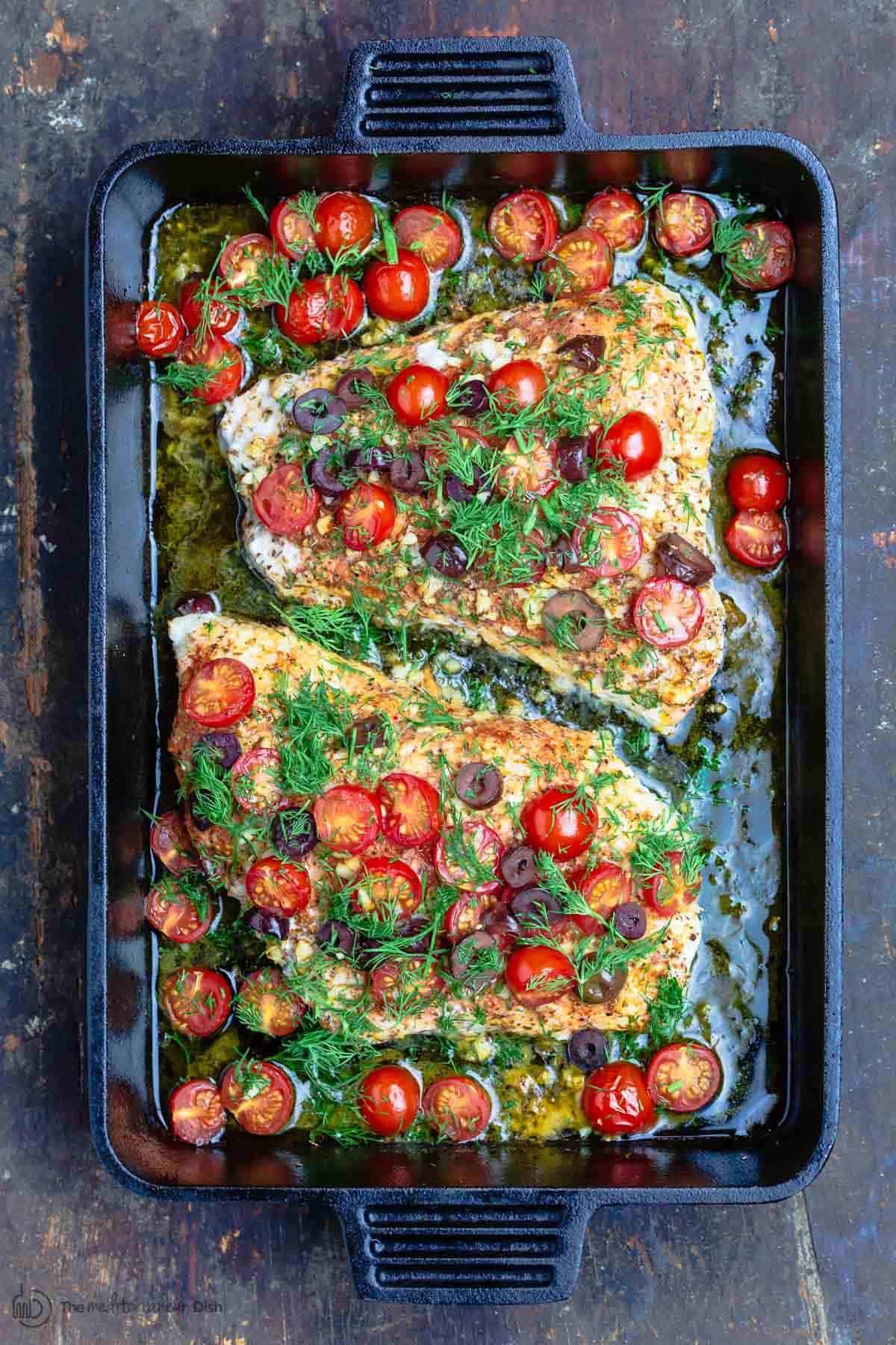 Baked grouper topped with tomatoes, olives and fresh dill