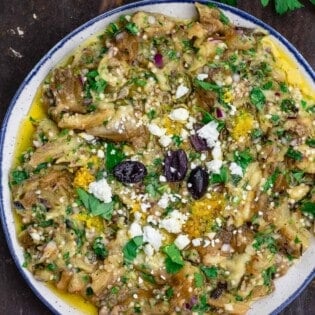 melitzanosalata (Greek eggplant dip) garnished with parsley, feta and olives