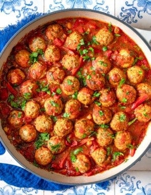 moroccan fish kofta in a large pot next to a blue cloth napkin.