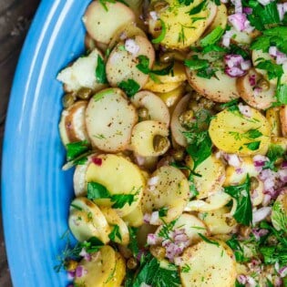 Mustard potato salad served on platter, garnished with dill and parsley