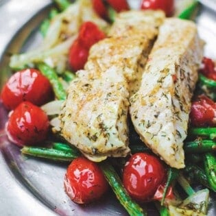 One Pan Baked Halibut Recipe | The Mediterranean Dish. Halibut fillet with green beans and cherry tomatoes baked in a delicious Mediterranean sauce with garlic, olive oil and lemon juice. Comes together in less than 30 mins! See the step-by-step on The Mediterranean Dish.