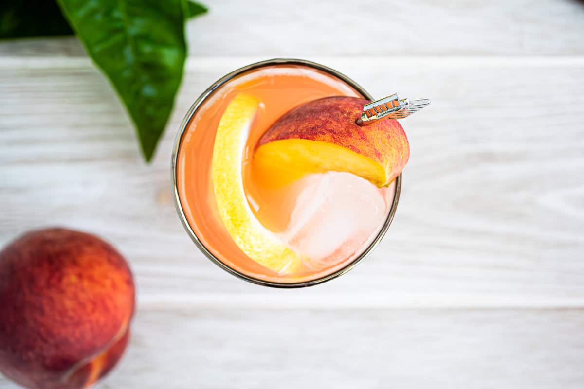 An overhead photo of the peach lemonade with a peach next to it.