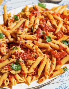 An overhead photo of arrabbiata sauce pasta on a serving platter with a spoon.