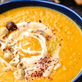 Overhead view of butternut squash soup topped with tahini and honey