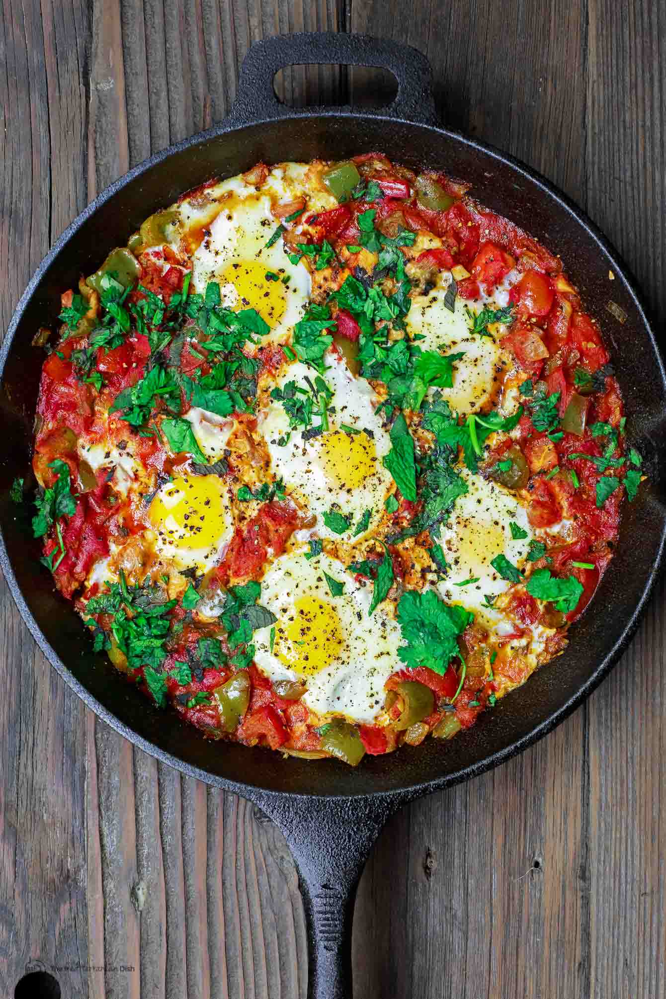 Simple Shakshuka Recipe | The Mediterranean Dish. Shakshuka is a delicious Middle Eastern dish of eggs poached in a spiced, saucy tomato stew. Perfect for breakfast, lunch or dinner! All you need to add is your favorite bread. This is a simple vegetarian recipe that you can make in less than 30 minutes! My family's favorite. And feeds a crowd on a small budget. See the recipe on TheMediterraneanDish.com