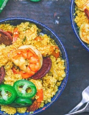 An overhead photo of shrimp couscous and 2 forks next to another bowl of the shrimp couscous.