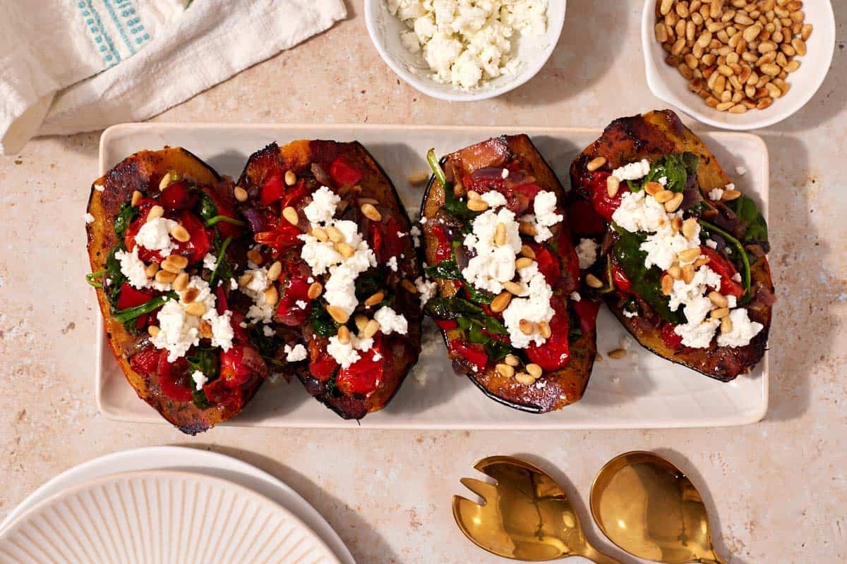 Overhead shot of stuffed squash with goat cheese and pine nuts on top.