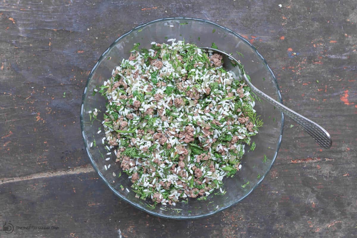 Stuffing for grape leaves. rice, meat, and fresh herbs combined in a bowl