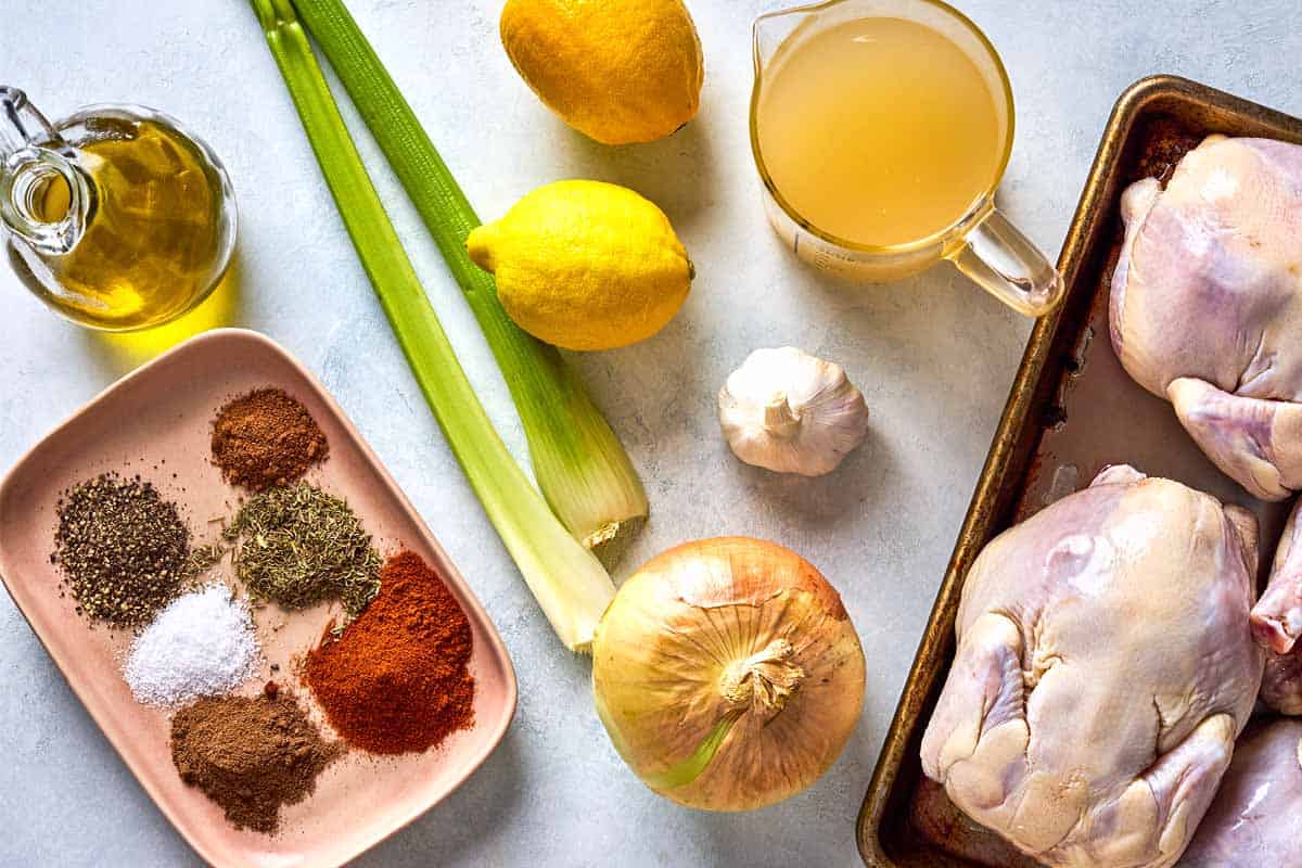 Ingredients for roasted cornish hens including cornish hens, celery, onion, lemon, chicken broth, garlic, salt, sweet paprika, allspice, dried thyme, black pepper, nutmeg, and olive oil.