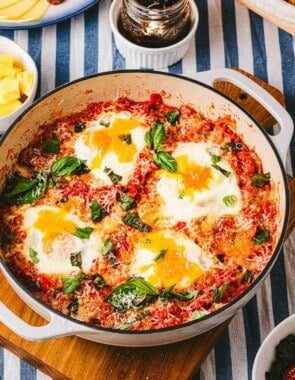 a skillet of eggs in purgatory next to a jar of jam.