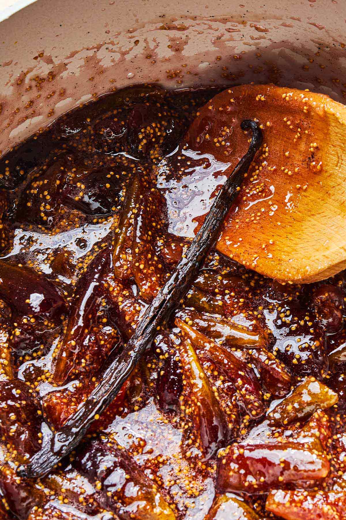 Fig jam simmering in a pot with a vanilla bean.