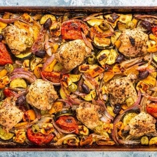 overhead photo of baked Greek sheet pan chicken and vegetables.