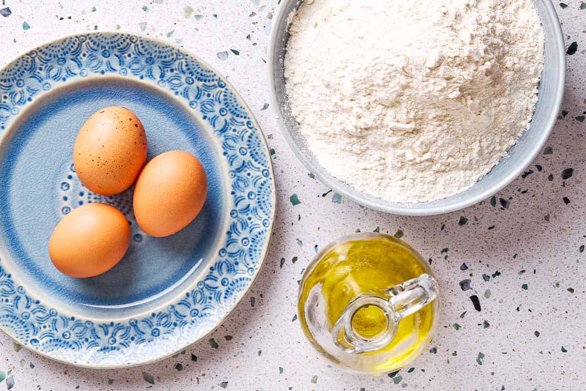 Ingredients for homemade past including eggs, flour and olive oil.