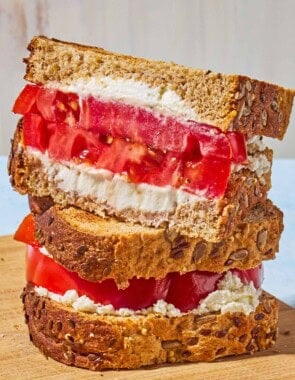 A close up of 2 tomato sandwiches stacked on top of each other.