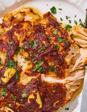 A close up of Turkish style salmon on a serving platter with a fork.