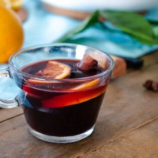 on cup of mulled wine with orange slices and a cinnamon stick.