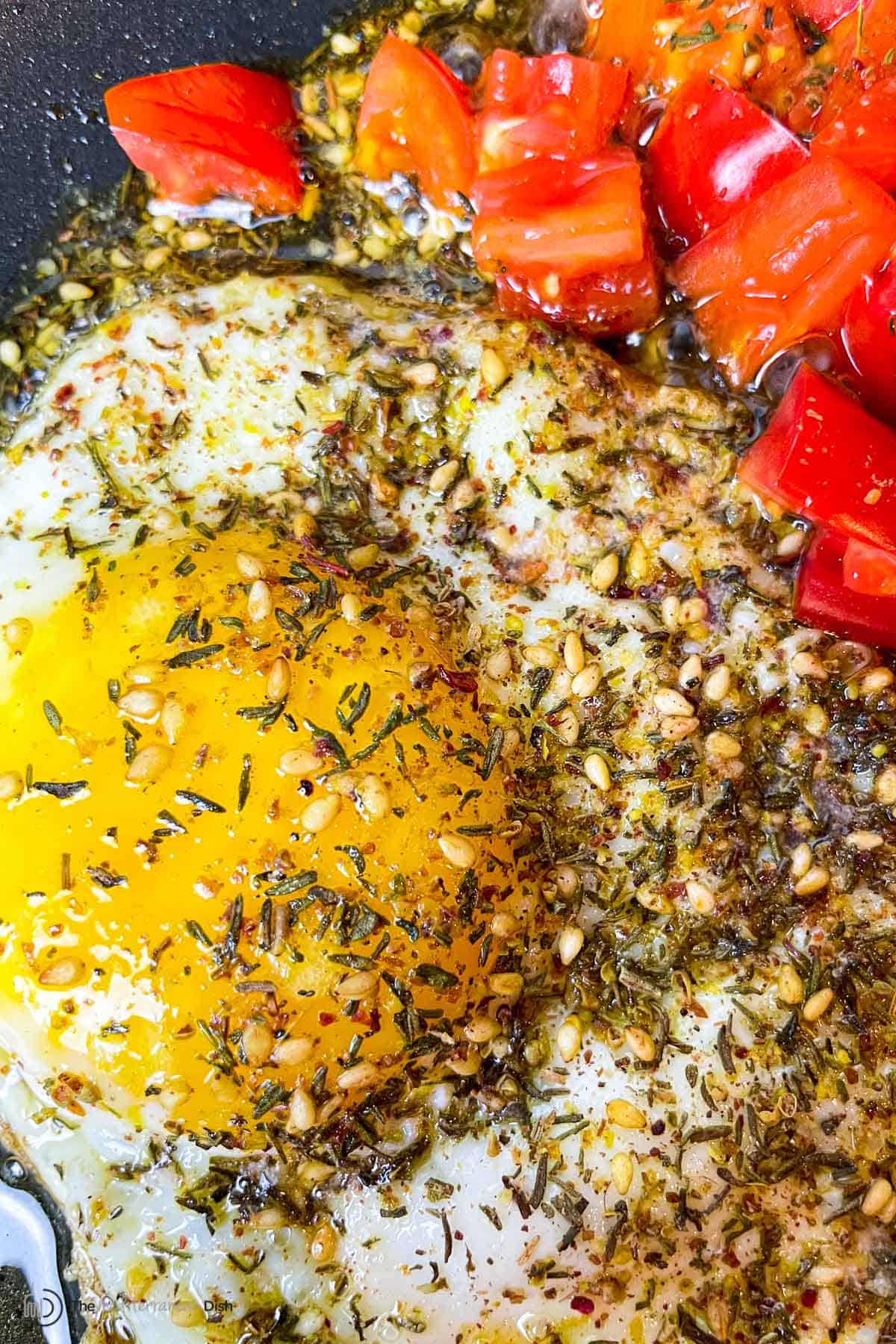 fried eggs with olive oil and za'atar and a side of chopped cherry tomatoes